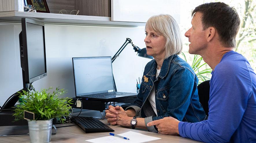 two people looking at the monitor and discussing
