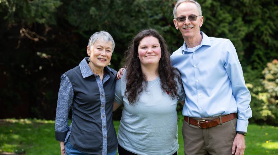 Three people posing in a park.