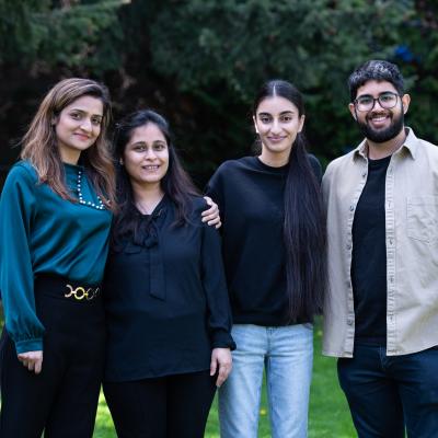 four people standing on the grass and smiling