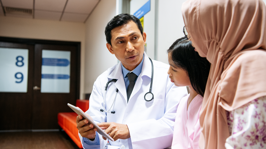 Doctor explaining something to a girl and to a woman wearing a hijab