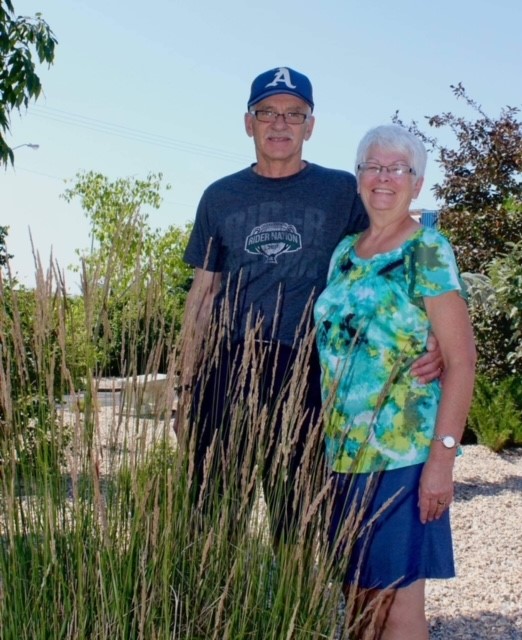 A picture of caregiver, Patti and her husband, George standing together, outside.